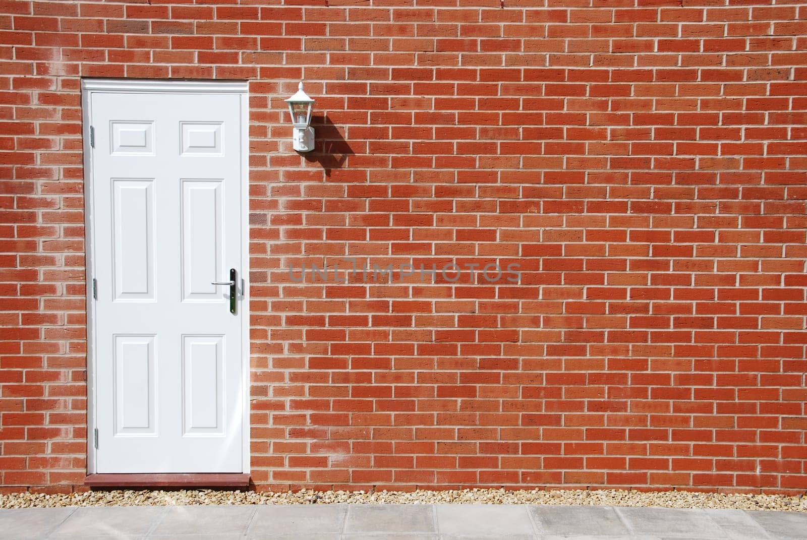 outdoor architecture with white door on a vibrant red brick wall