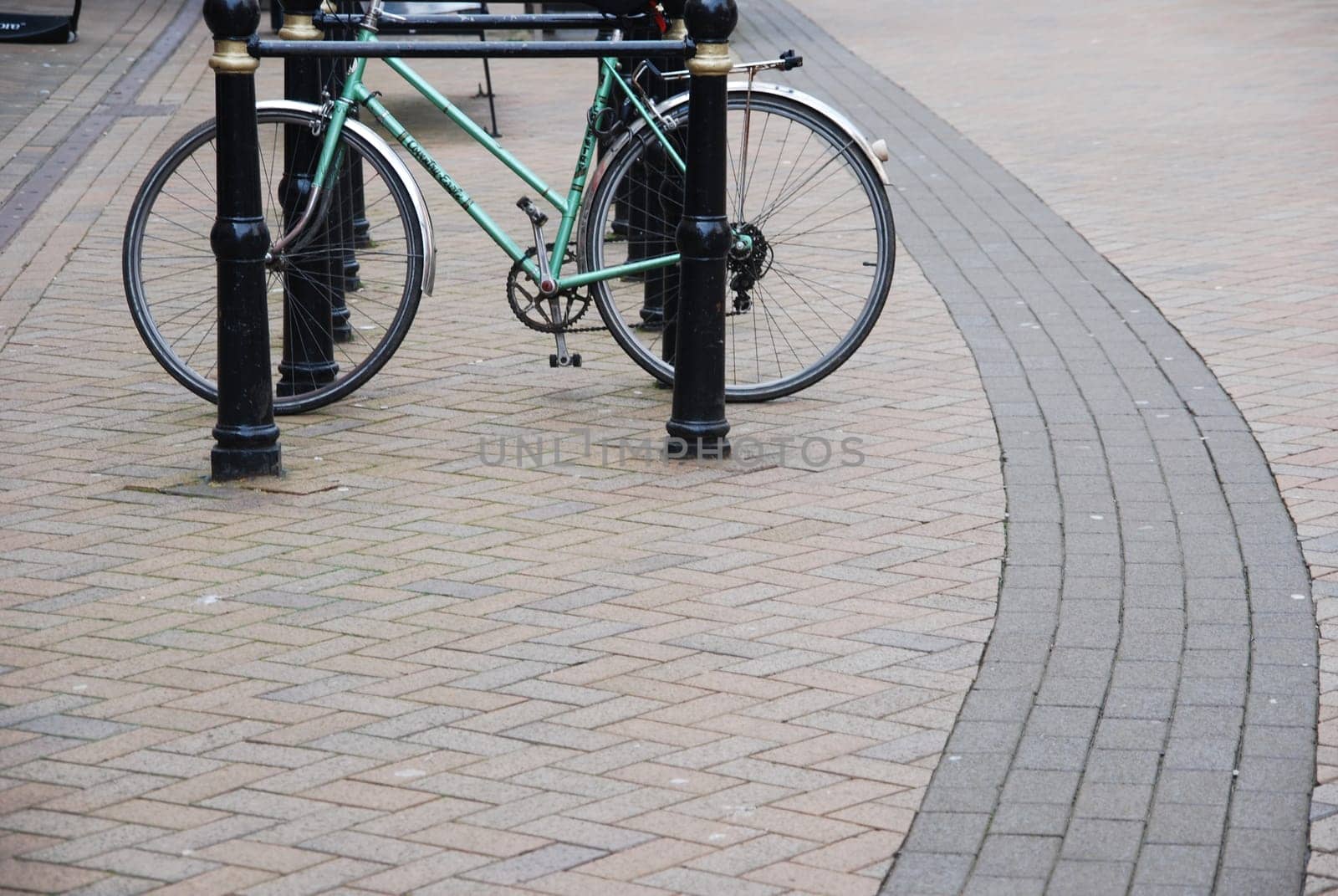 green bicycle on a parking rack at a urban street