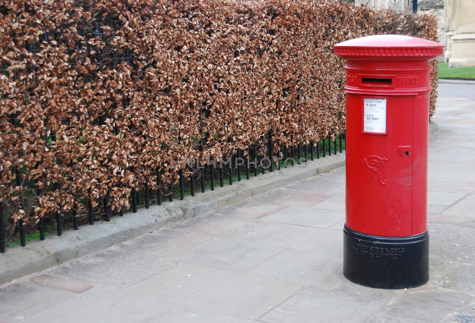 red and vintage british postbox on the sidewalk