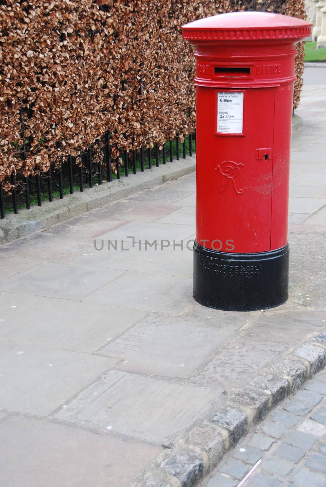 red and vintage british postbox on the sidewalk