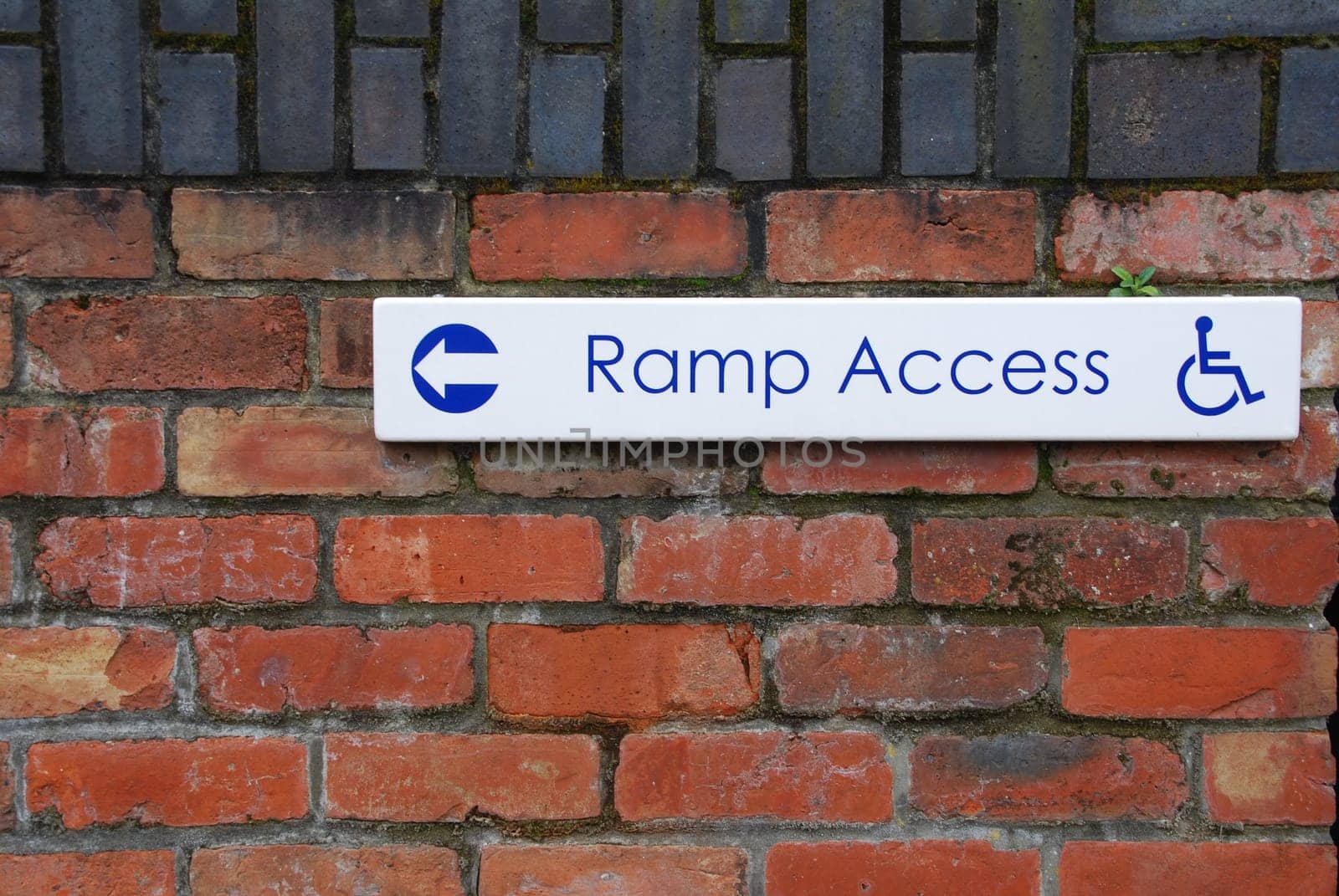 ramp access sign on a brick wall background