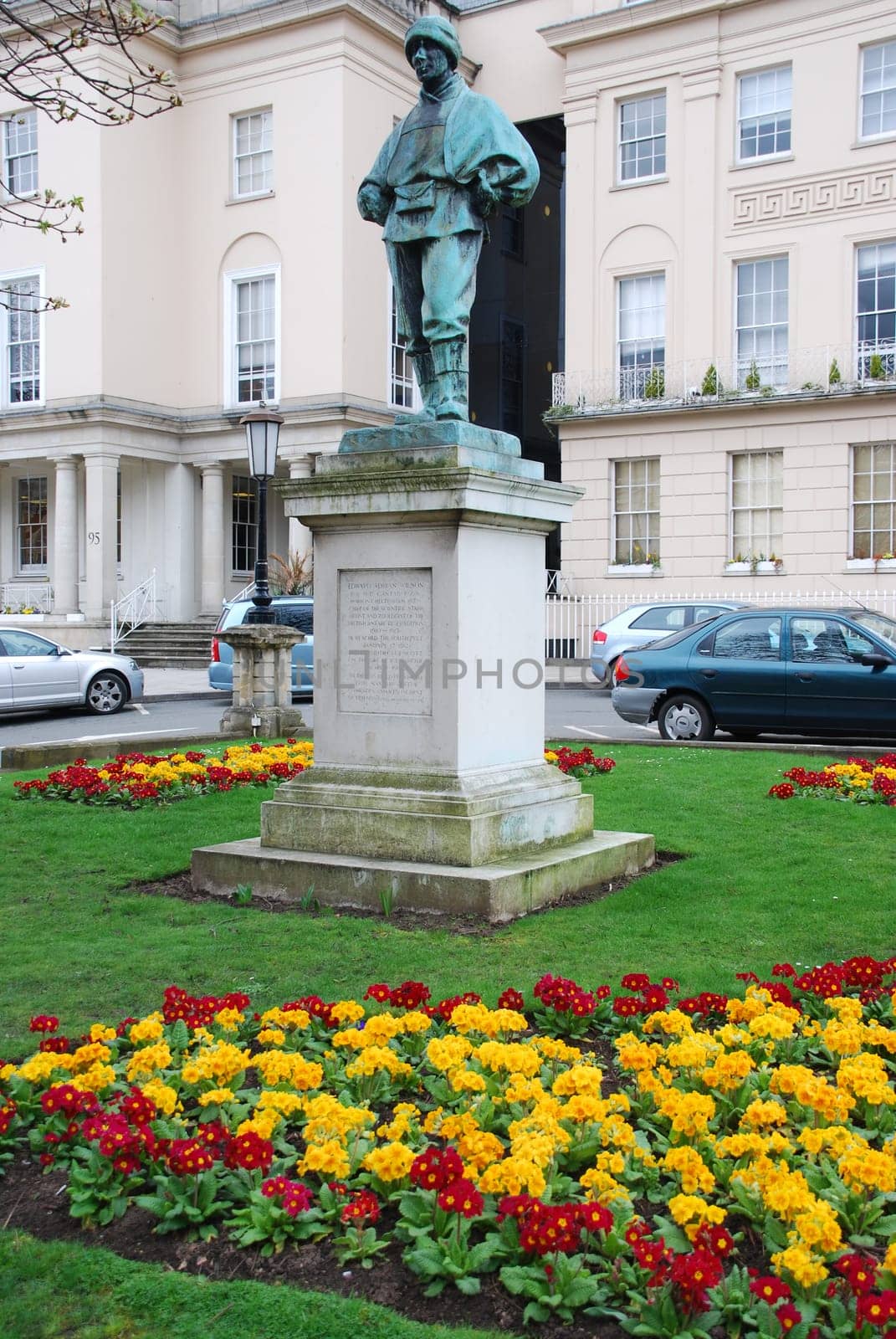 Edward Adrian Wilson statue on a colorful public garden in Cheltenham