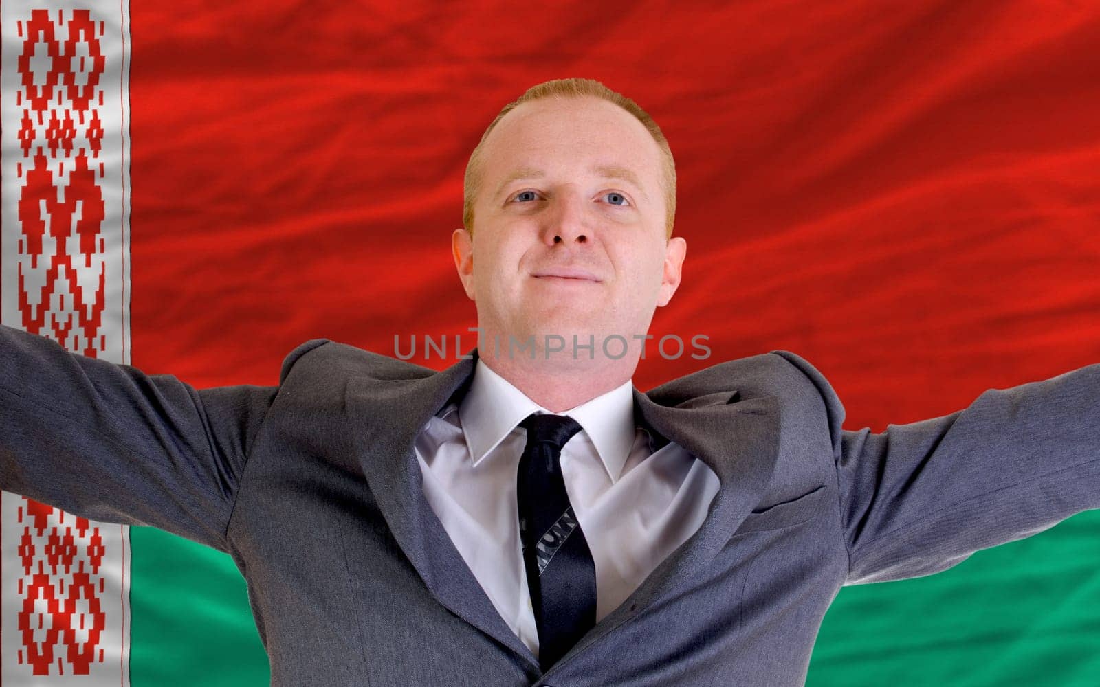 joyful investor spreading arms after good business investment in belarus, in front of flag