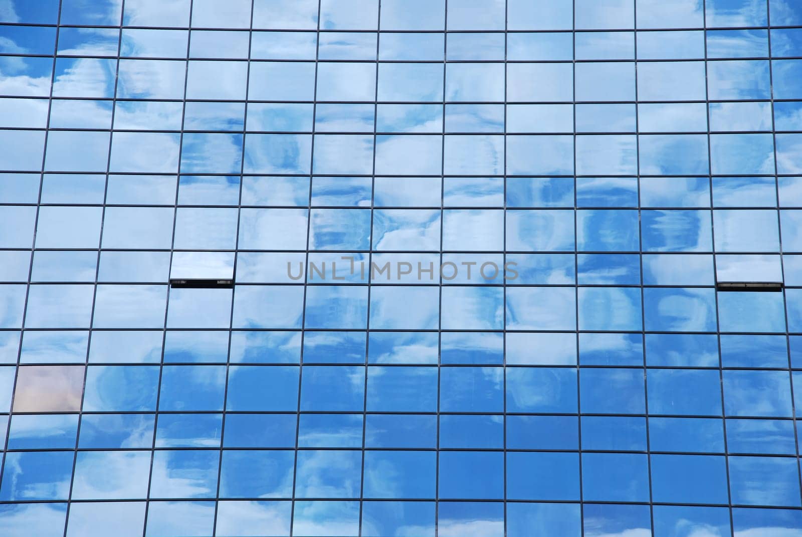 modern office building with glass pattern with clouds reflected