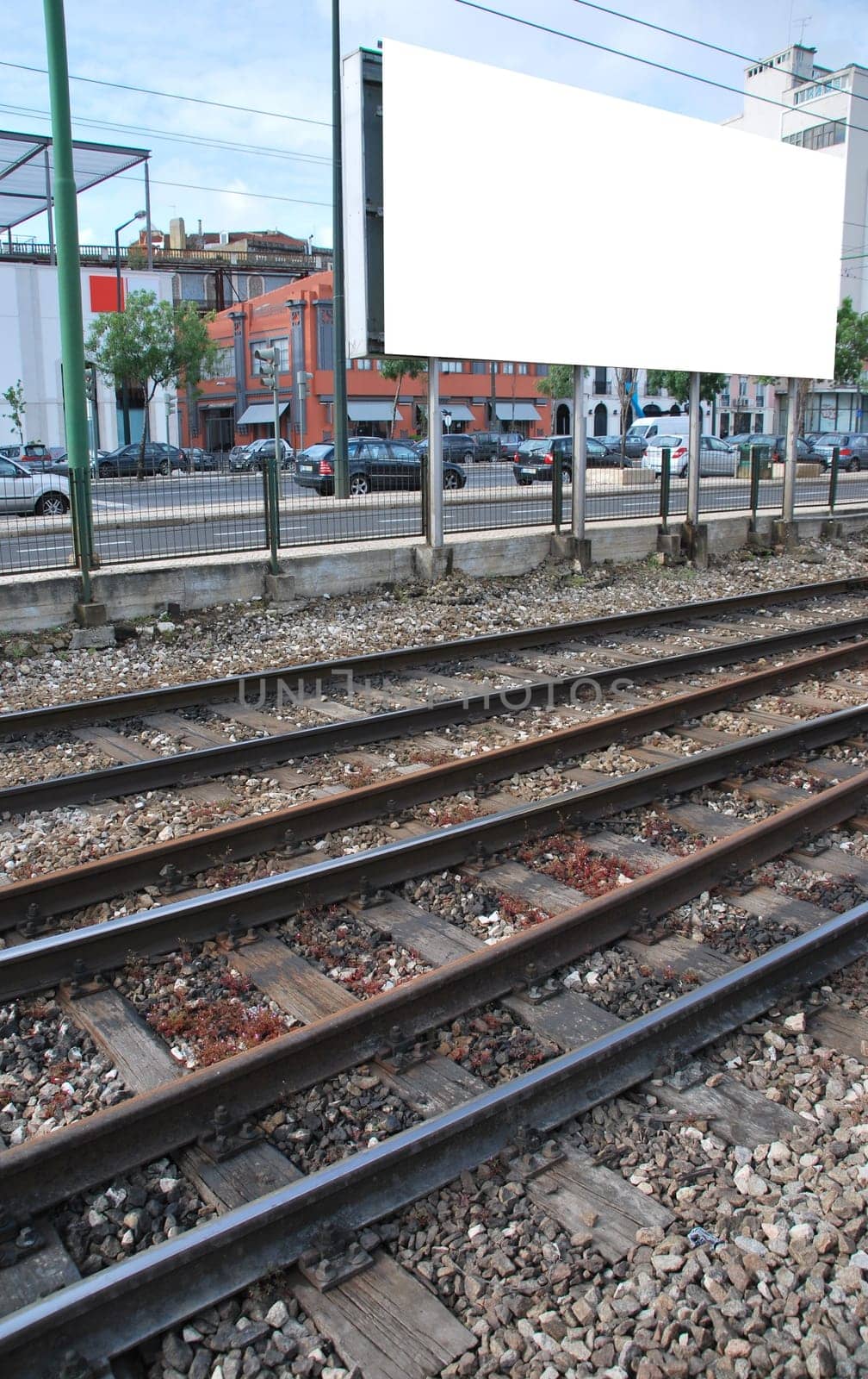 big and empty billboard behind railway tracks at a urban place