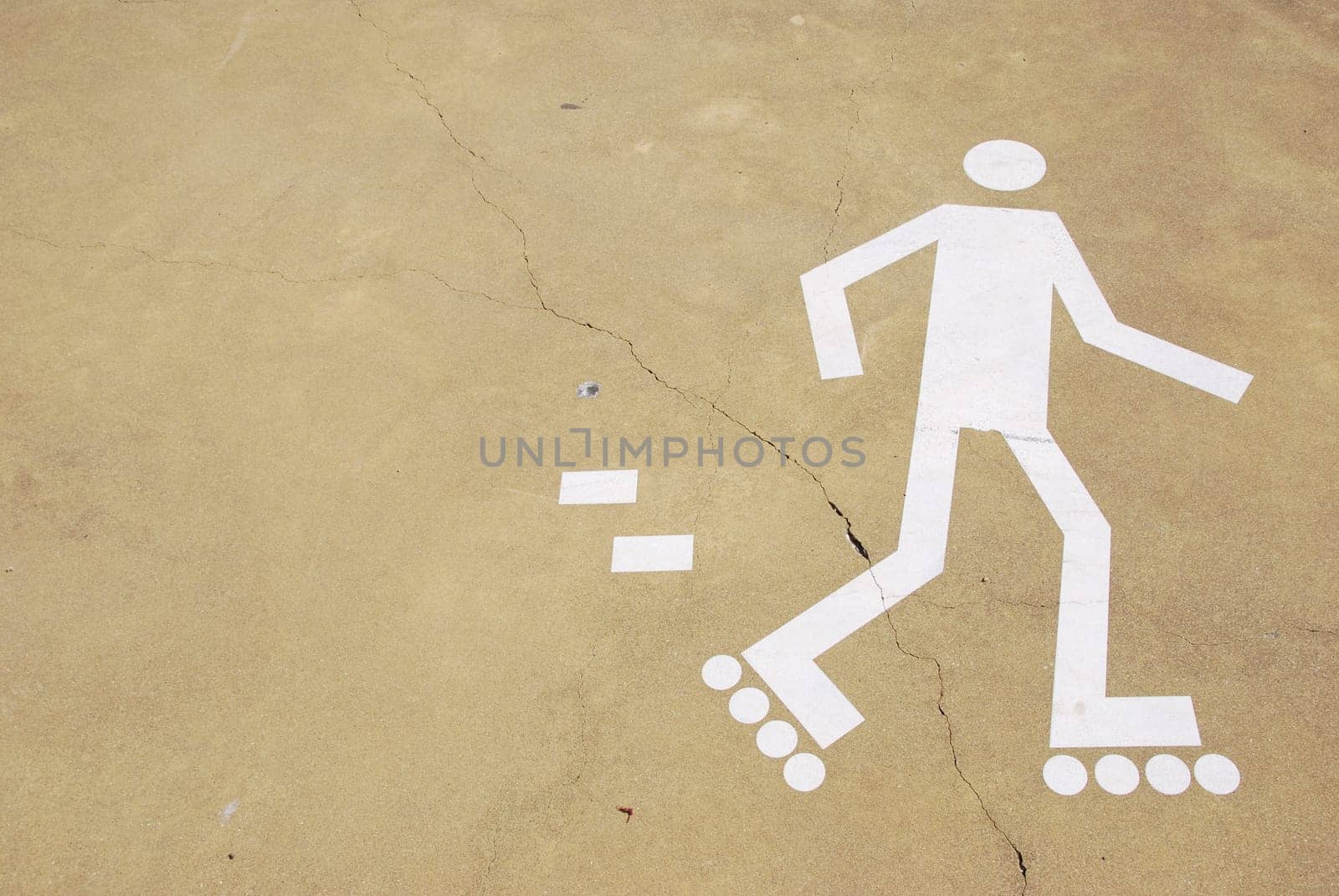 white rollerblading sign on a urban park (yellow cement surface)