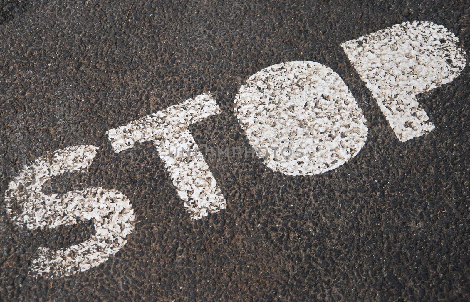 stop sign painted on a asphalt road surface