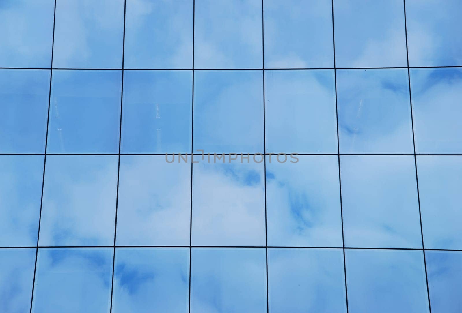 modern office building with glass pattern with clouds reflected
