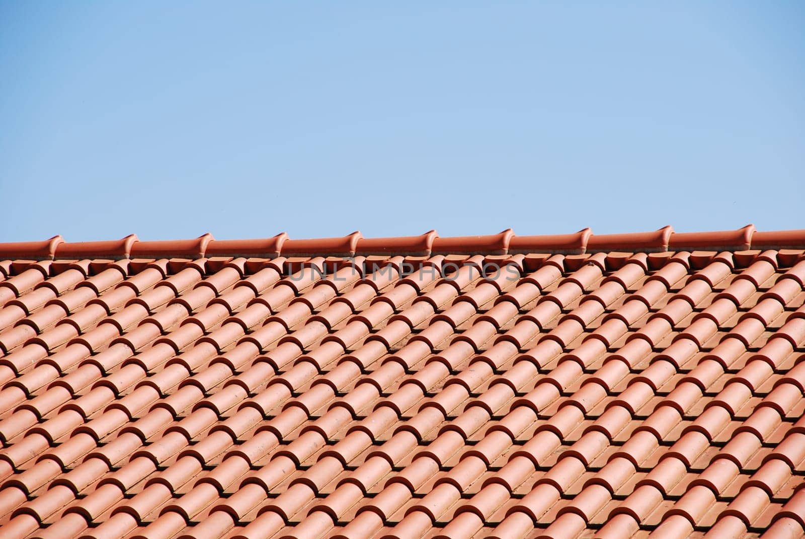 orange tiles on the roof of a house against blue sky background