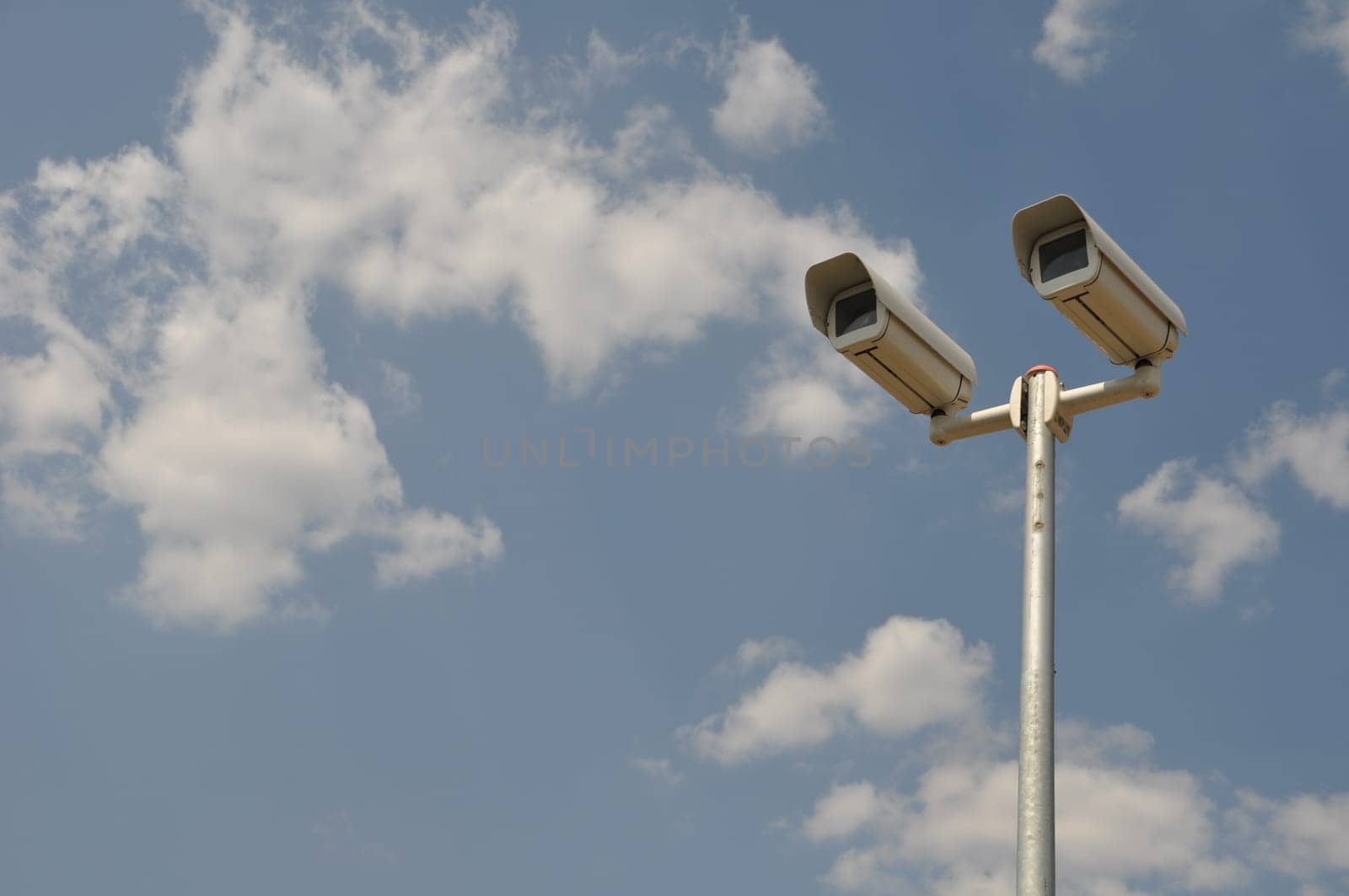 video surveillance cameras against blue sky background