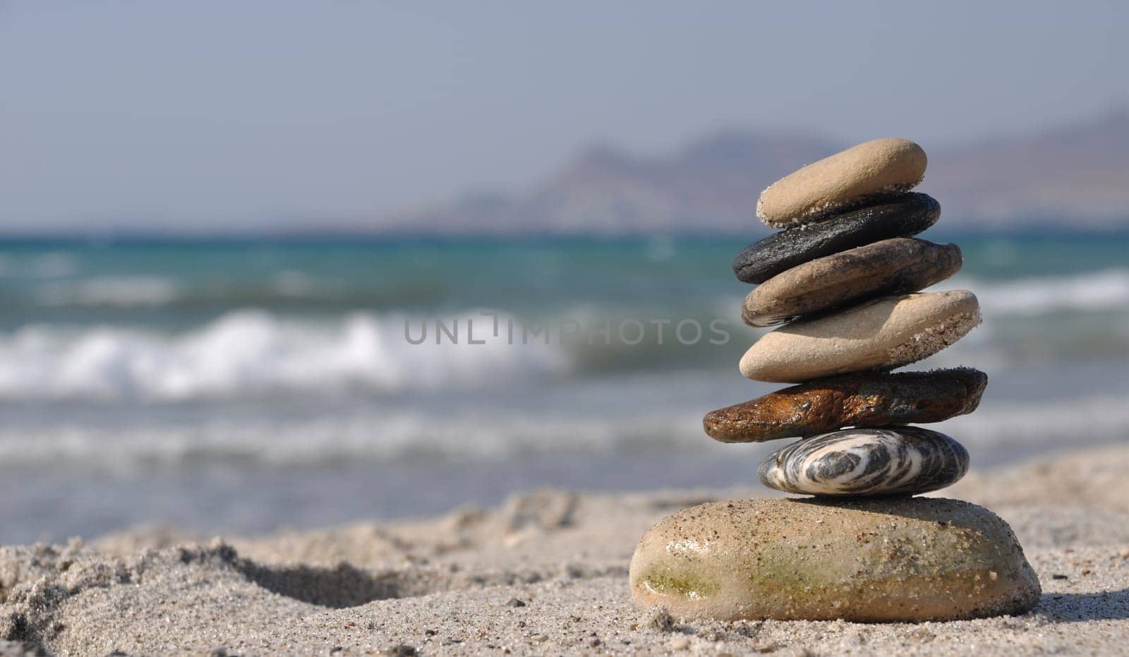 beautiful pebble stack on a sandy beach (sea on the background)