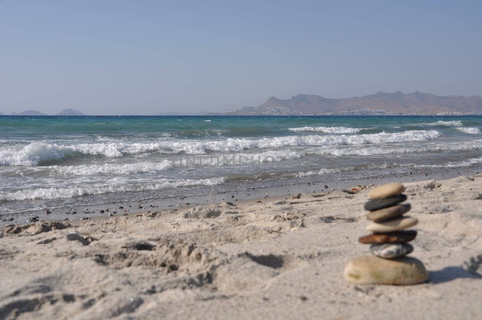 beautiful Kos beach with defocused pebble stack, Greece (Turkey on background)