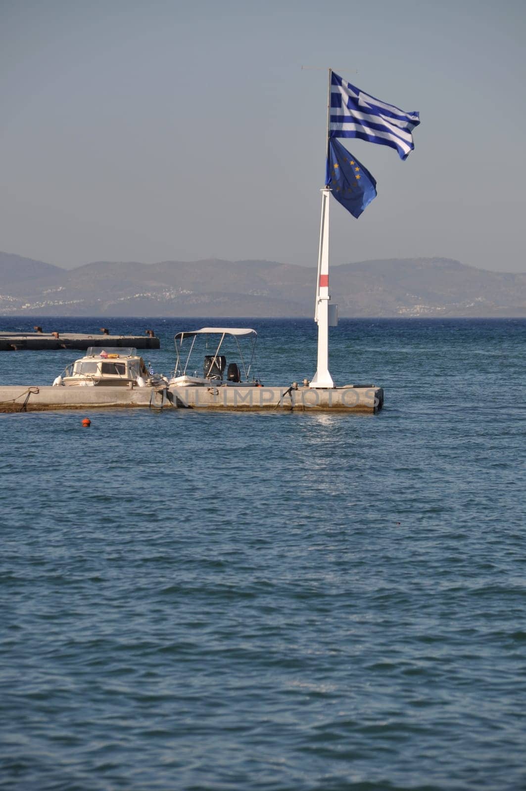 Greece and EU flags at Kos harbour (seascape view)