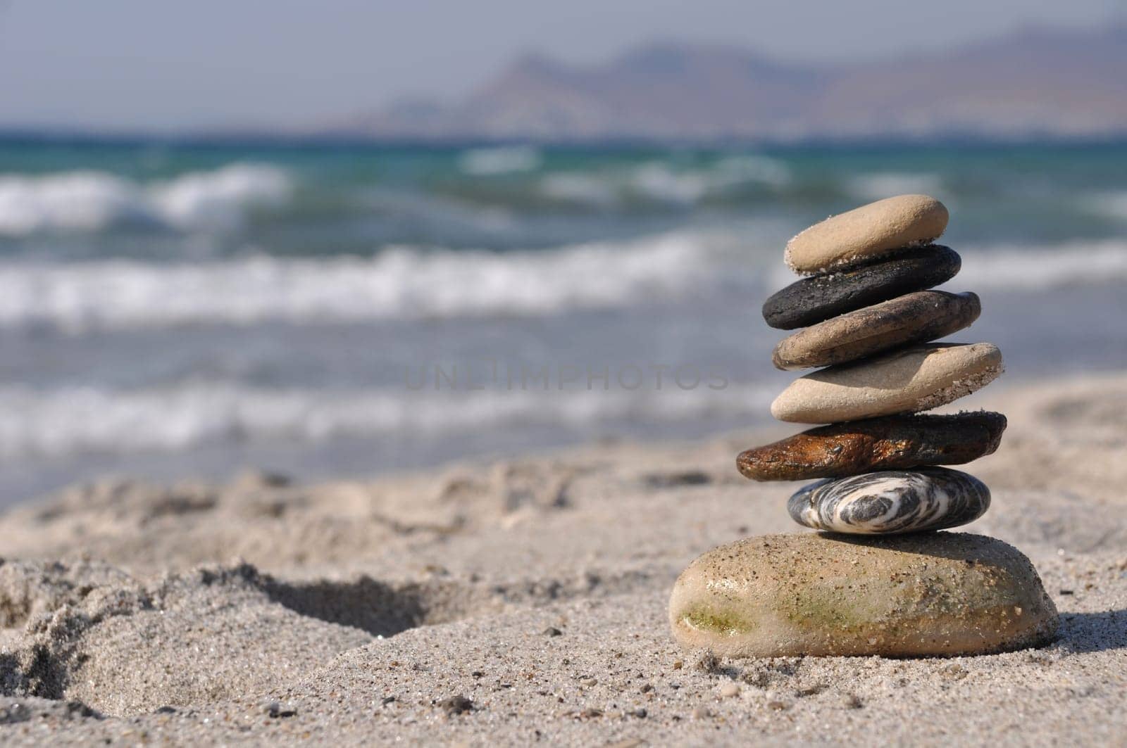 beautiful pebble stack on a sandy beach (sea on the background)