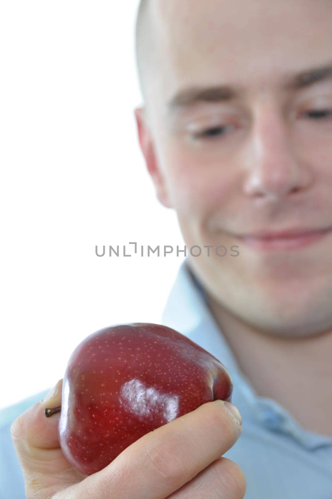 Young man eating fresh apple isolated on white background