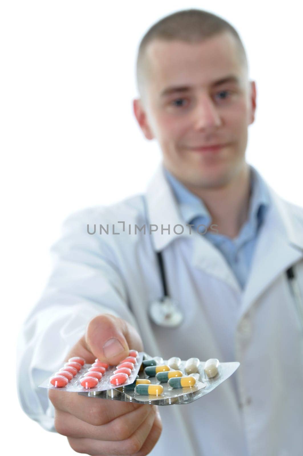 Young doctor offering many drugs. Isolated on white background.