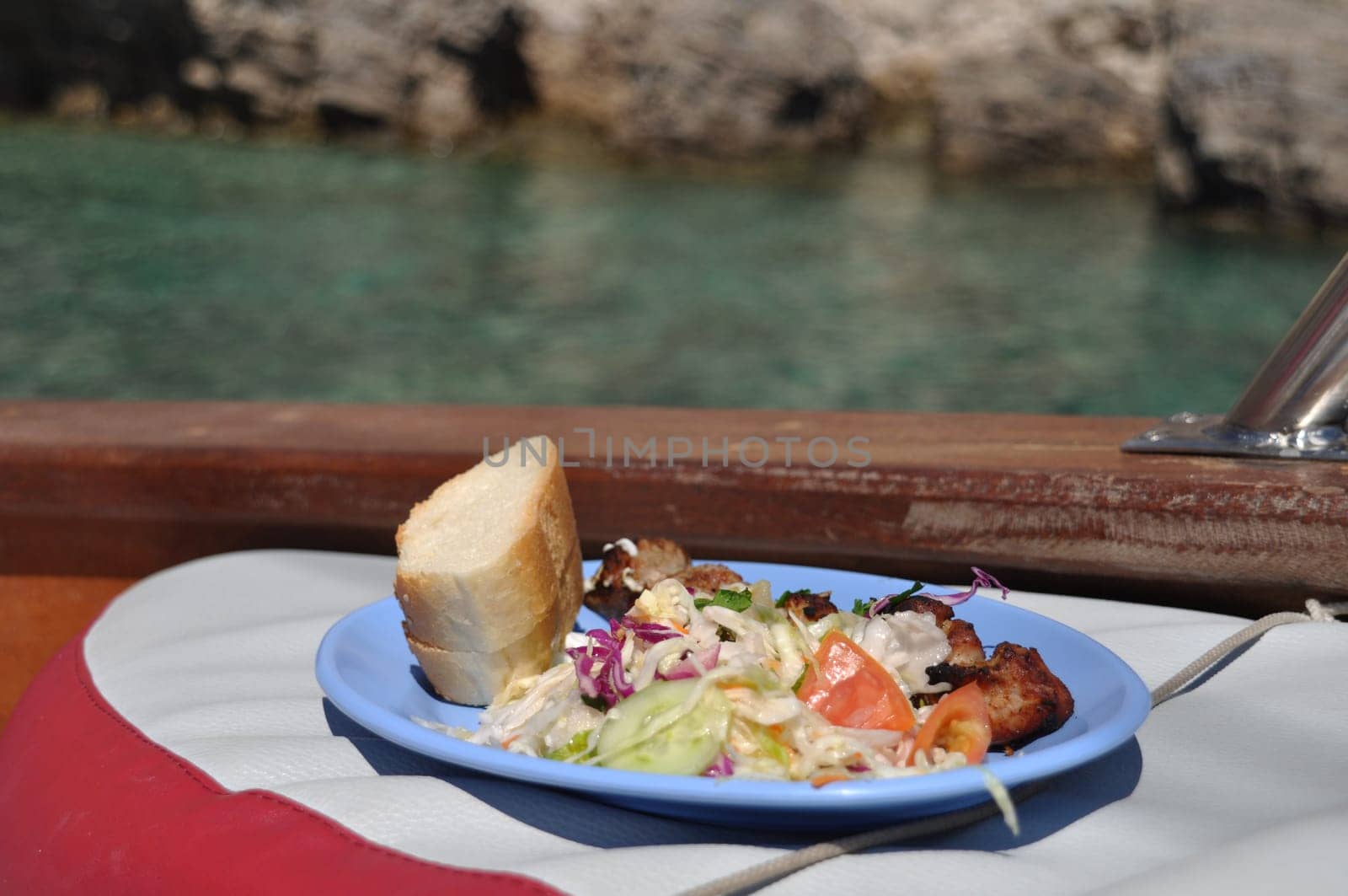 delicious grilled chicken on spit, salad and bread (lunch on board of a cruising boat)