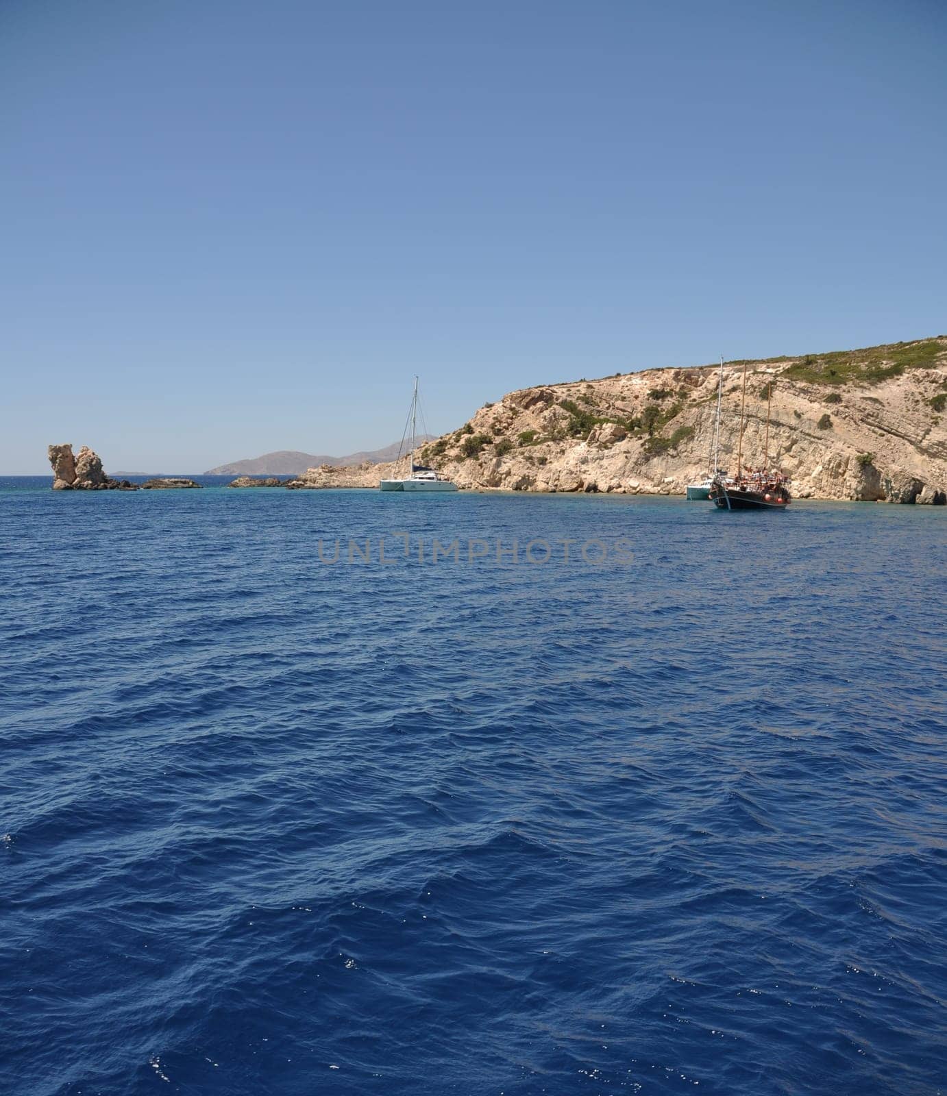 beautiful desert or uninhabited island in Greece with sailing/cruising boats