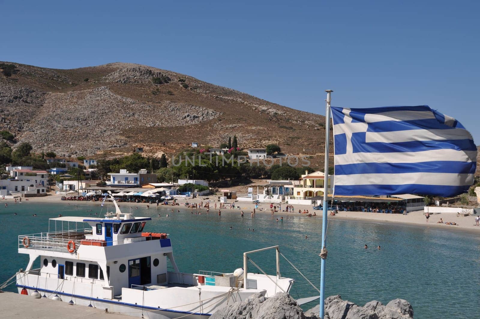 beautiful bay of Pserimos island with Greece flag