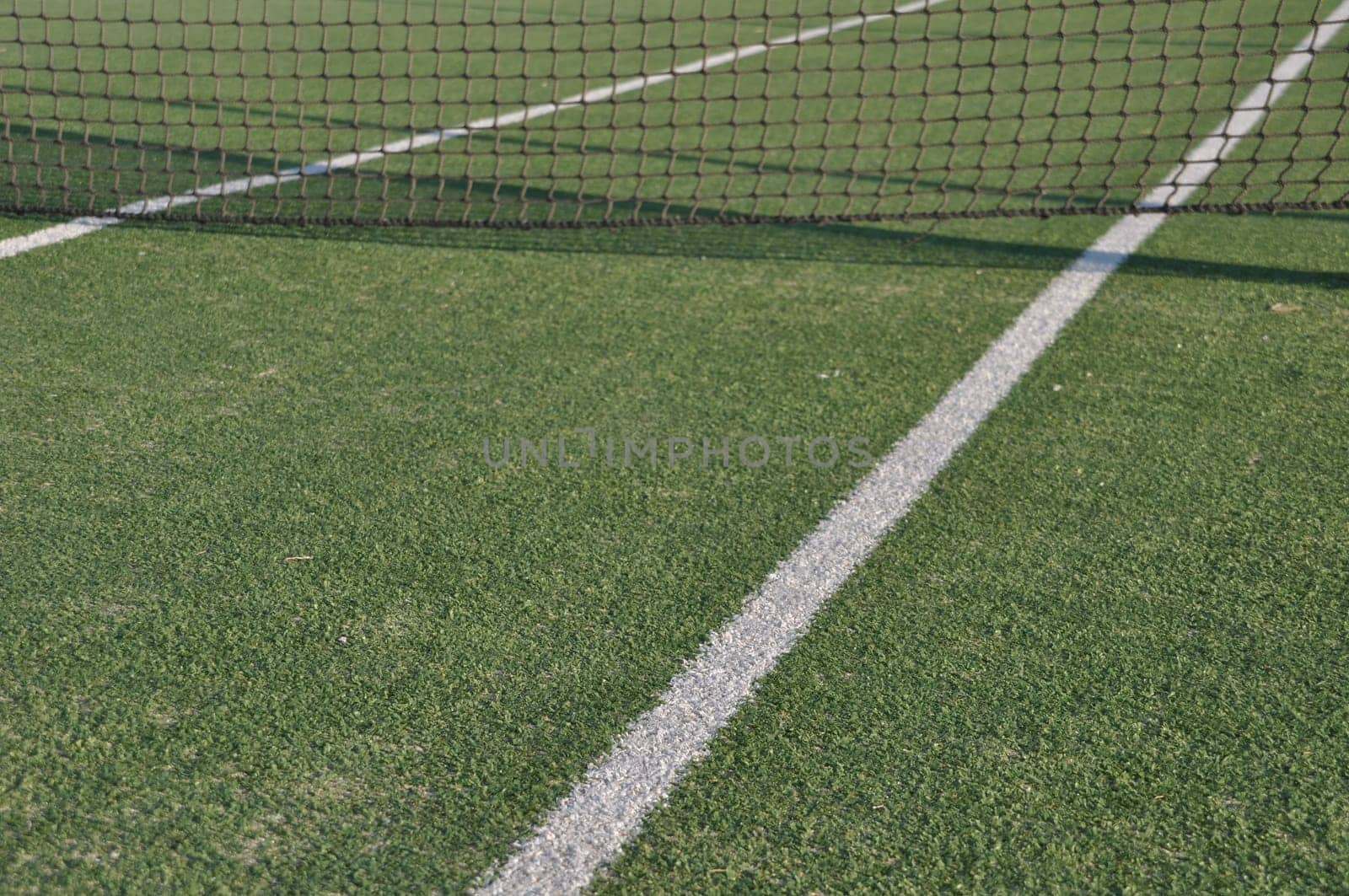 white lines on an outdoor tennis court (artificial grass)