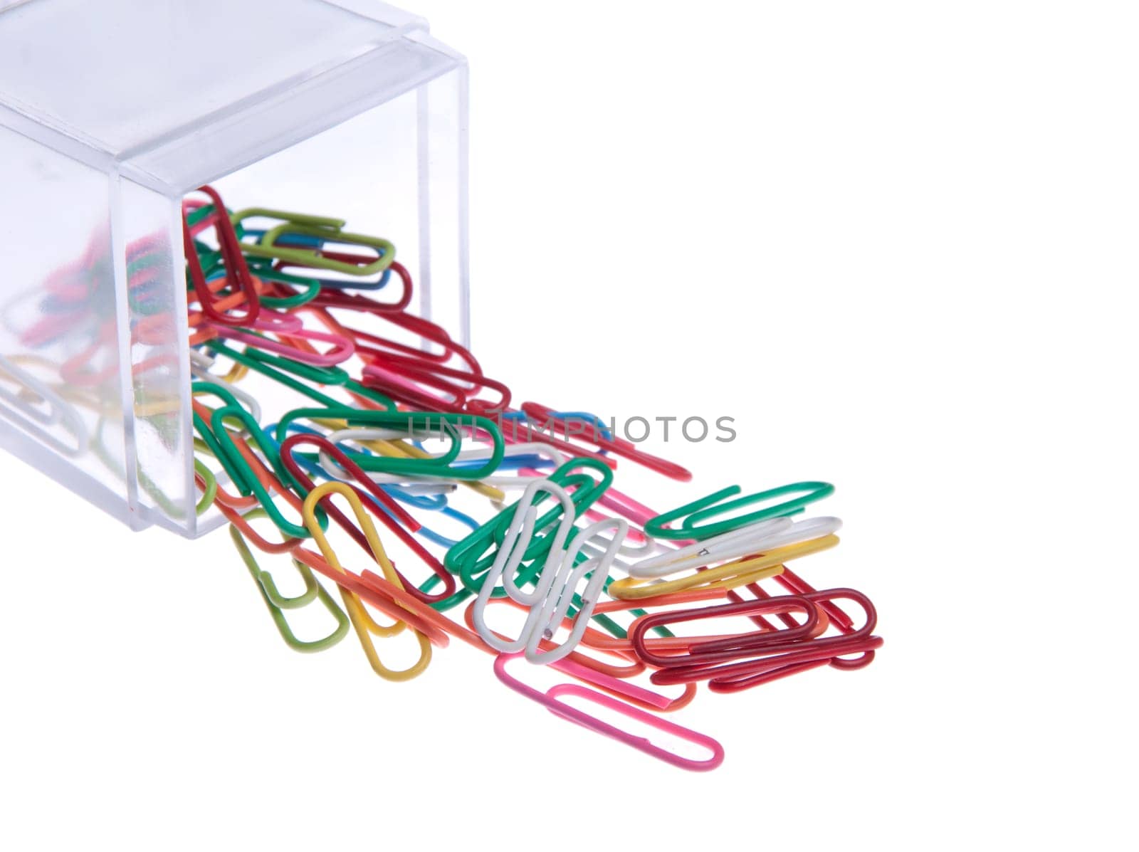 colored paper clips outside a plastic box isolated on white background