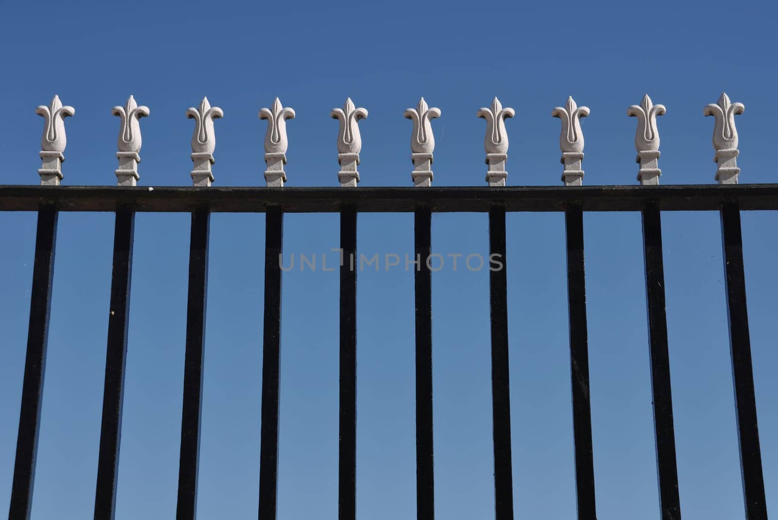 detail of a iron gate against blue sky background