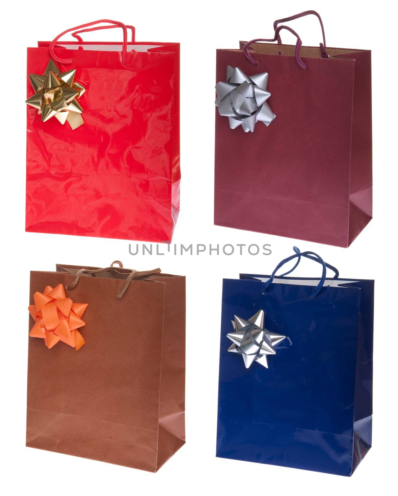 four colorful gift paper bags with bows isolated on white background