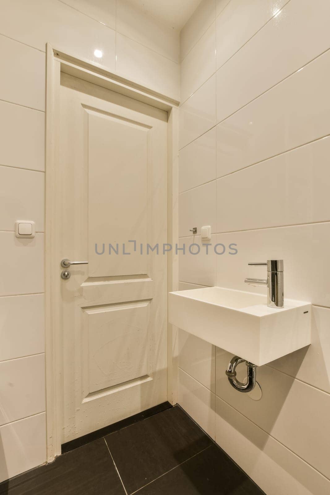 a white bathroom with a sink and a white door by casamedia