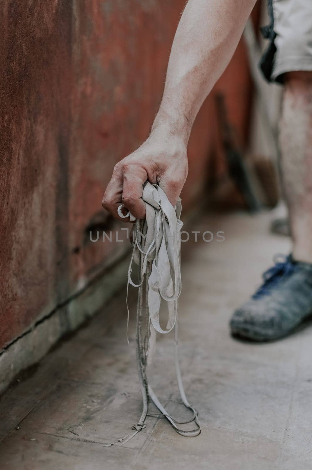 Young caucasian unrecognizable man holding old,dirty and removed window silicone in his hands, closeup side view. The concept of home renovation, installation of windows, construction work.