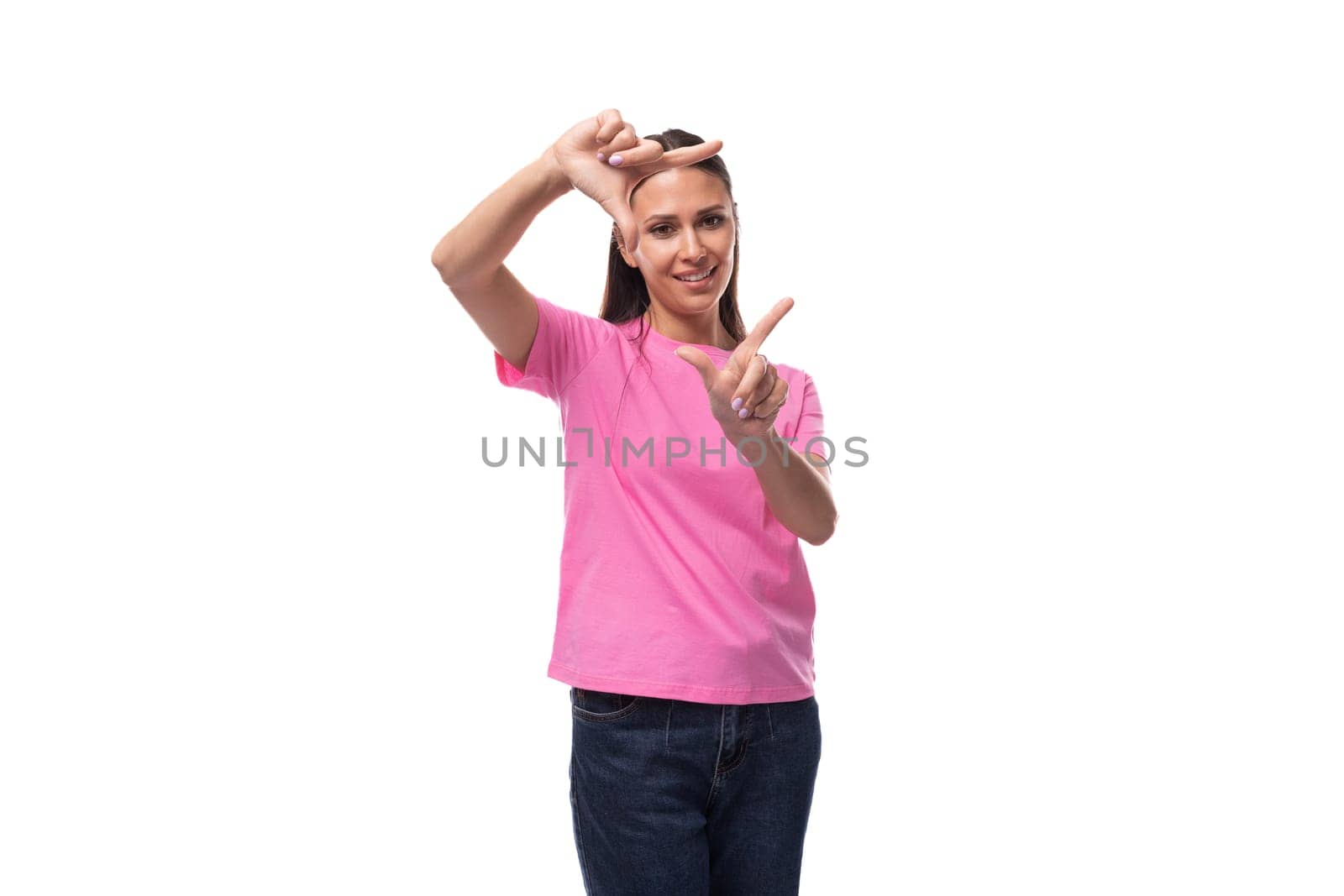 young beautiful model woman with straight black hair dressed in a pink t-shirt shows a frame with her hands.