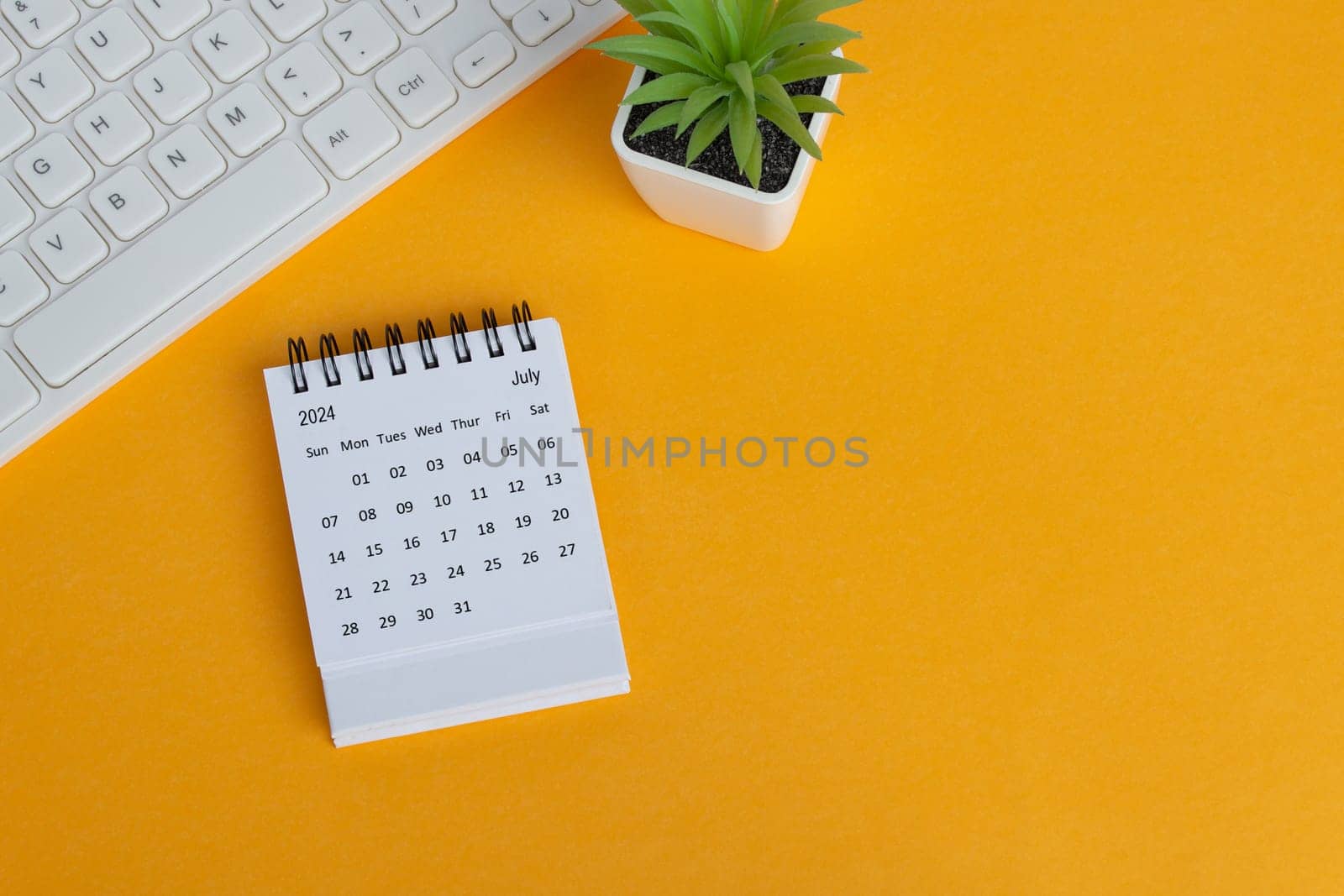 July 2024 desk calendar on yellow background. Directly above. Flat lay. Copy space.