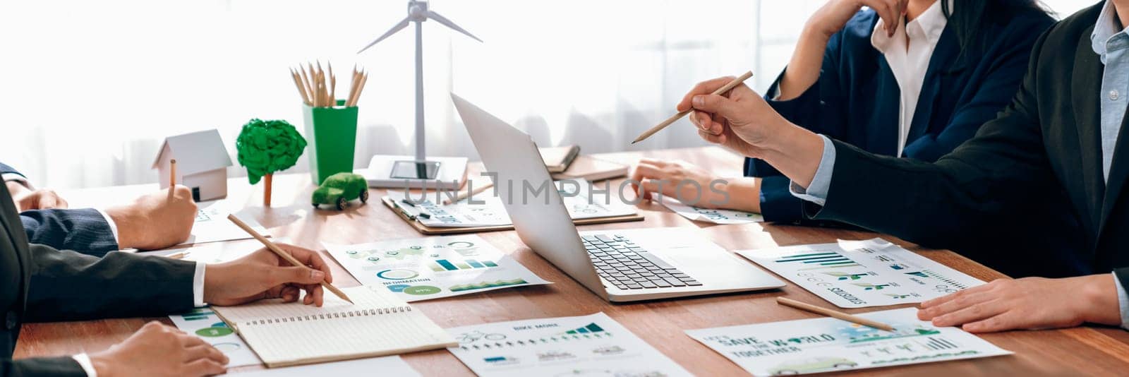 Eco business company meeting with group of business people using laptop to plan strategy and discuss marketing of eco-friendly and clean energy products. Green business company concept. Trailblazing