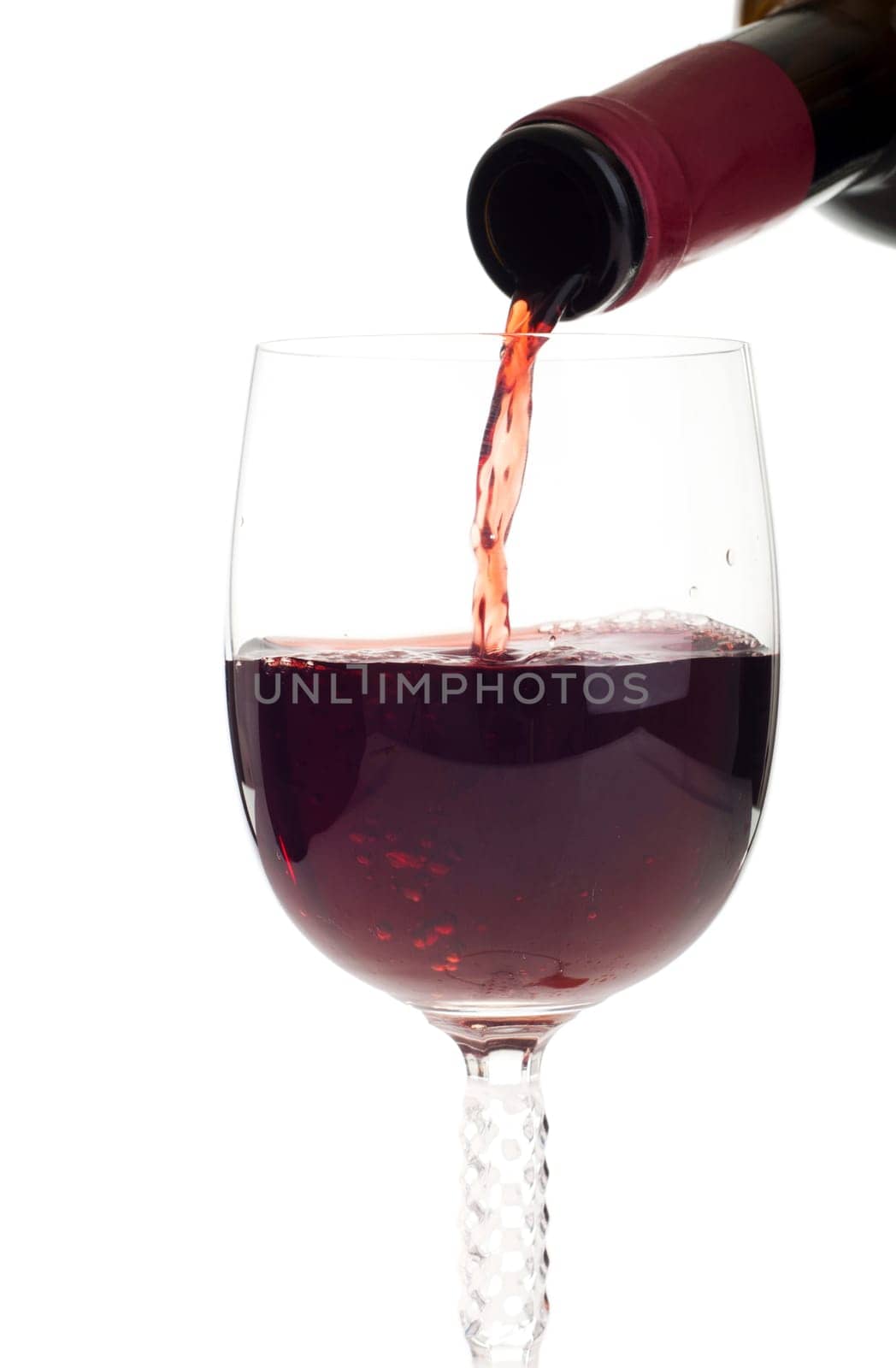 bottle pouring red wine into a crystal glass (isolated on white background)