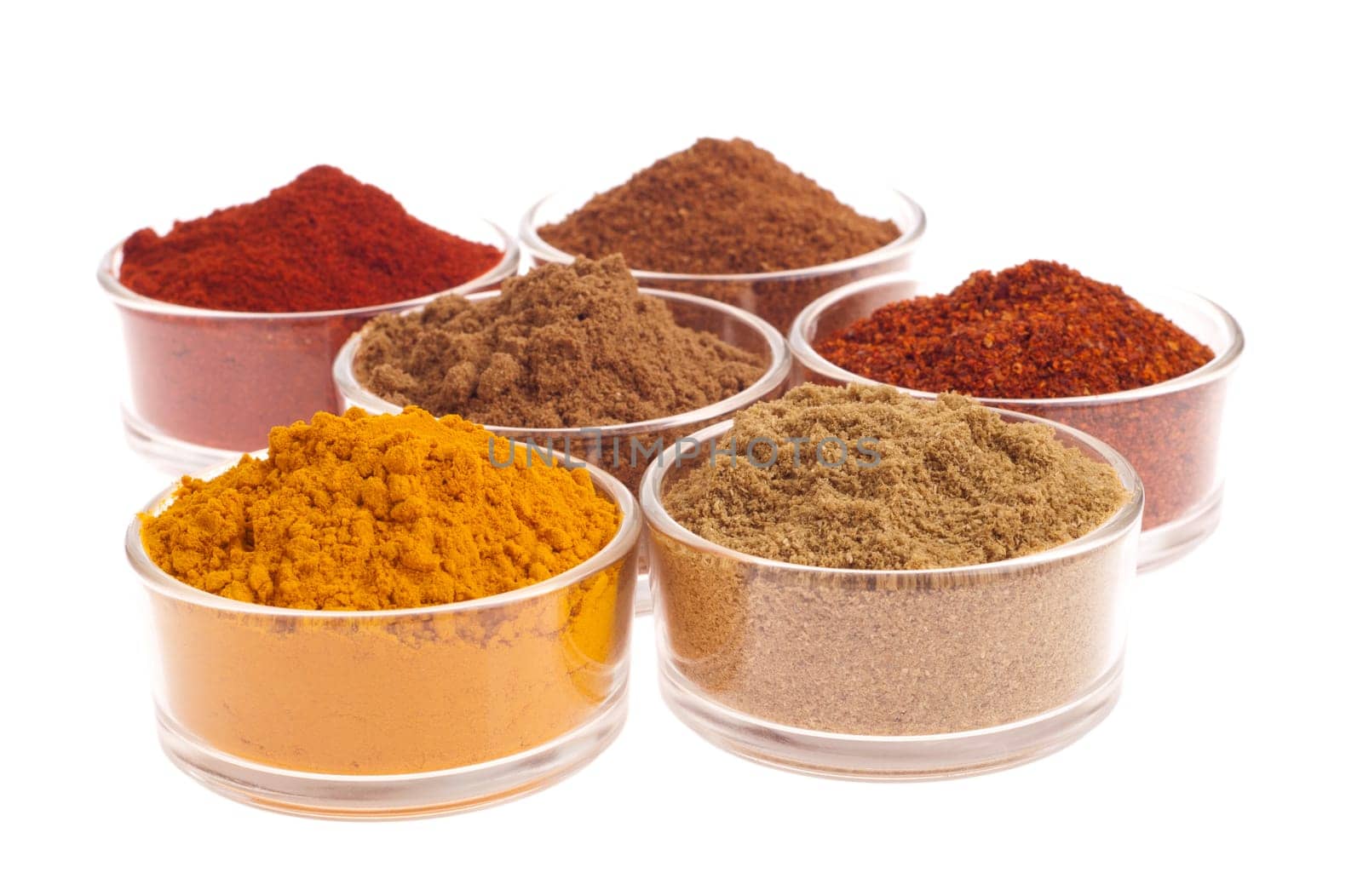 collection of indian spices (cumin, coriander, paprika, garam masala, curcuma, chili powder) on glass cups isolated on white background