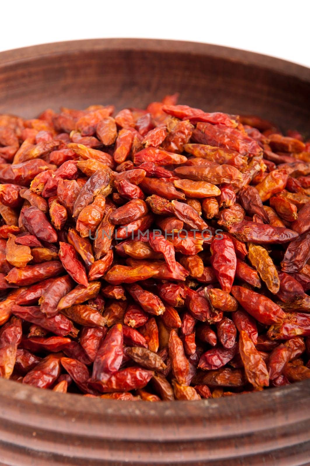 Piri Piri peppers on a vintage wooden bowl (close-up picture, isolated on white background)