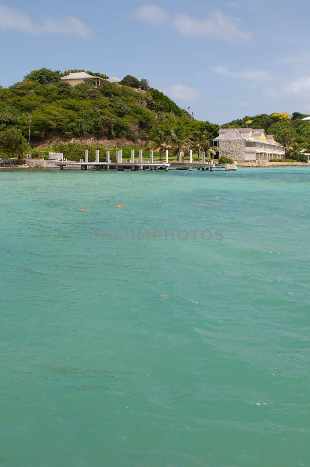 Antigua Long Bay, gorgeous seascape view surrounded by tropical nature and some typical houses
