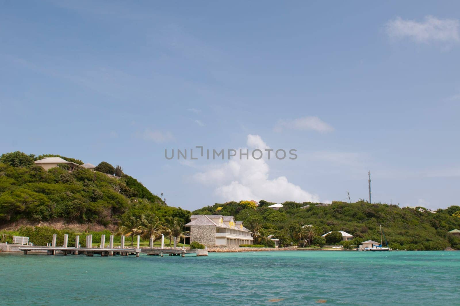 Antigua Long Bay, gorgeous seascape view surrounded by tropical nature and some typical houses