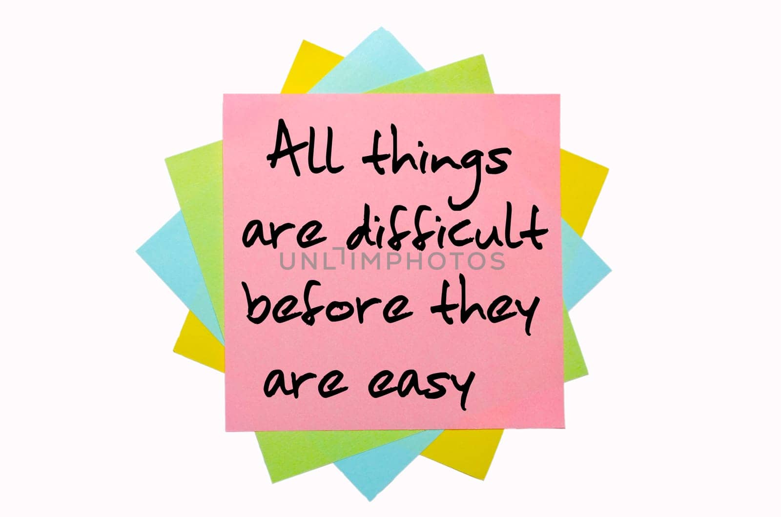 text "All things are difficult before they are easy"" written by hand font on bunch of colored sticky notes"