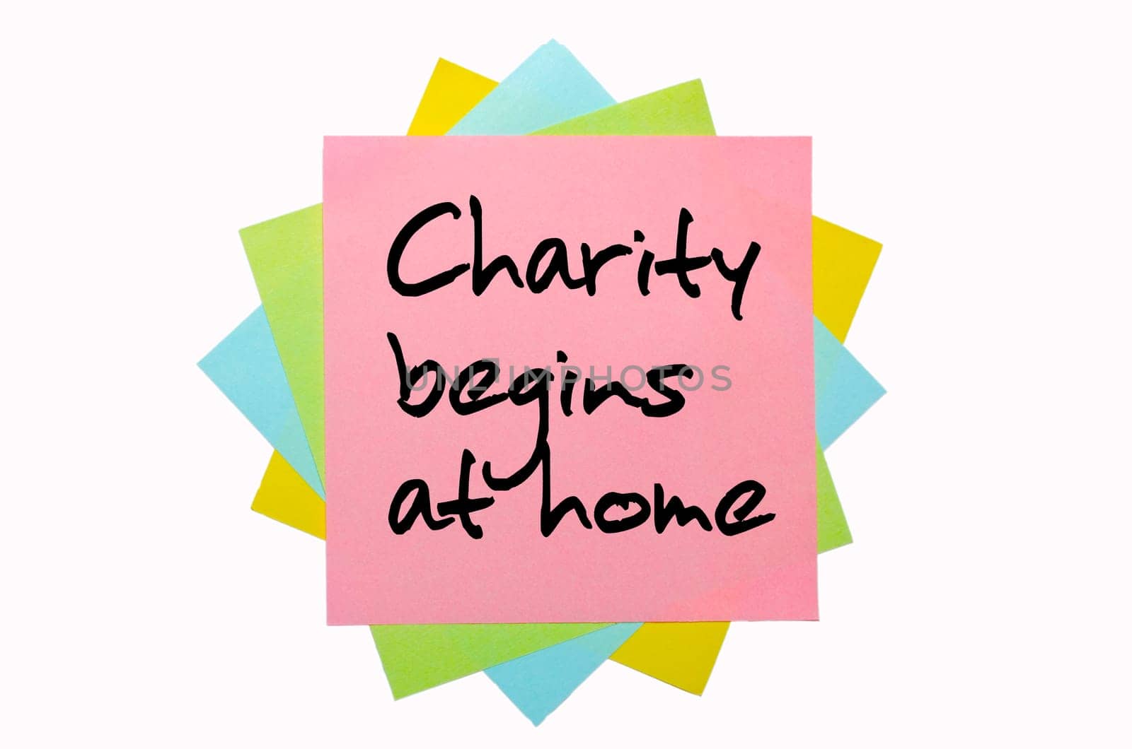 text "Charity begins at home"" written by hand font on bunch of colored sticky notes"