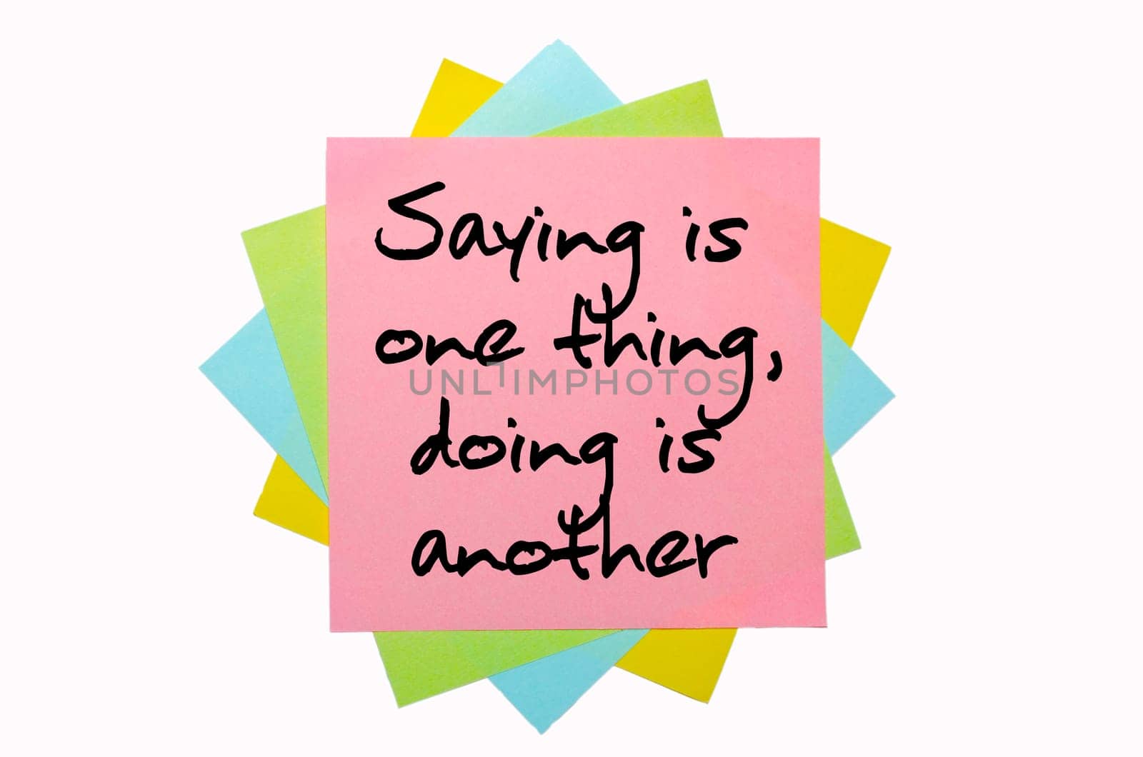 text " Saying is one thing, doing is another "" written by hand font on bunch of colored sticky notes"
