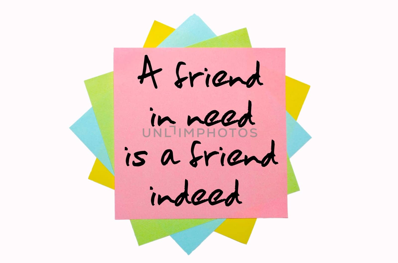 text "A friend in need is a friend indeed"" written by hand font on bunch of colored sticky notes"