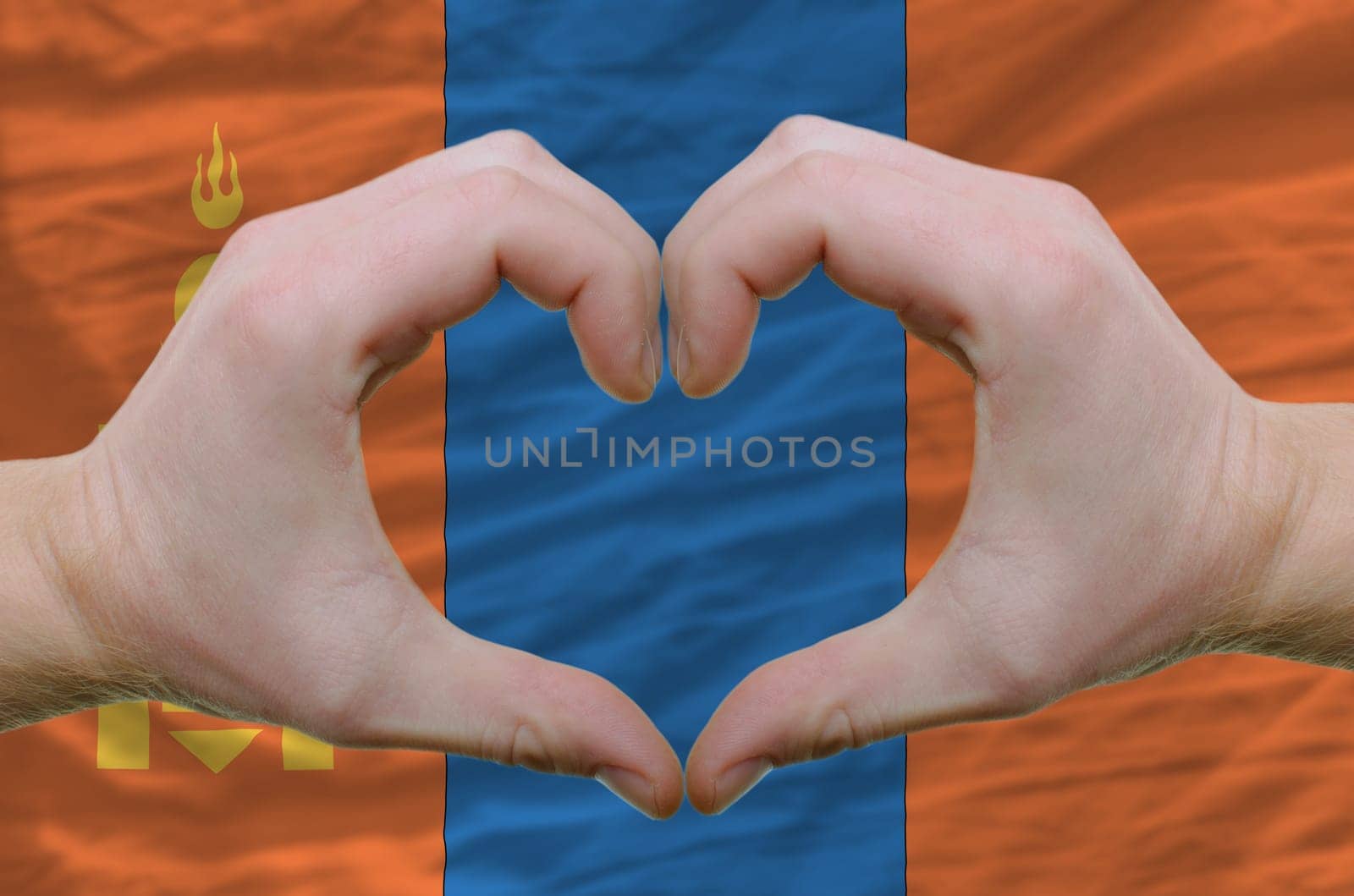 Gesture made by hands showing symbol of heart and love over mongolia flag