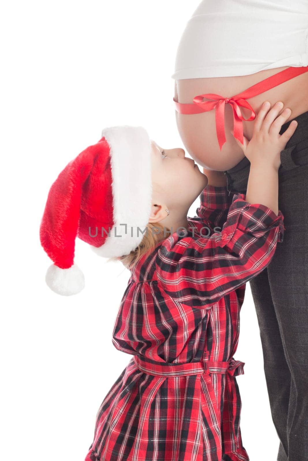 the studio shot of little girl kissing christmas gift - pregnant mother