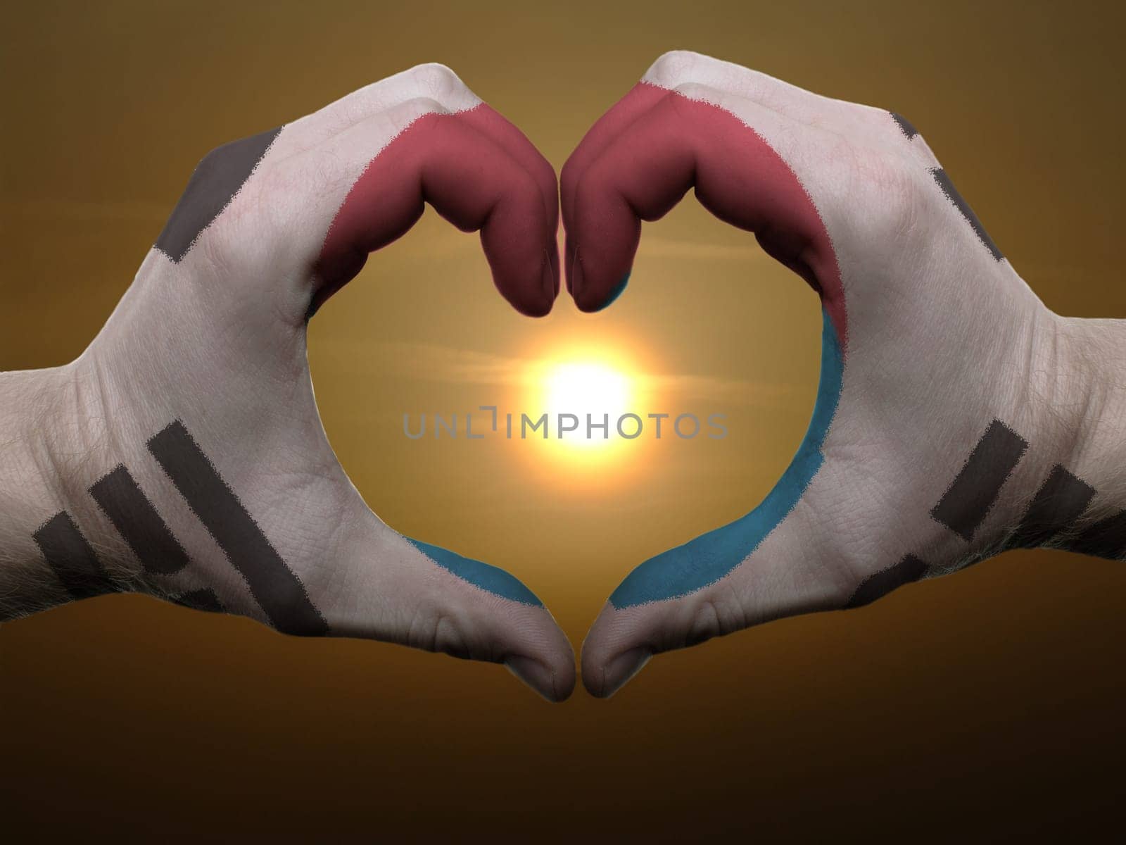 Gesture made by south korea flag colored hands showing symbol of heart and love during sunrise