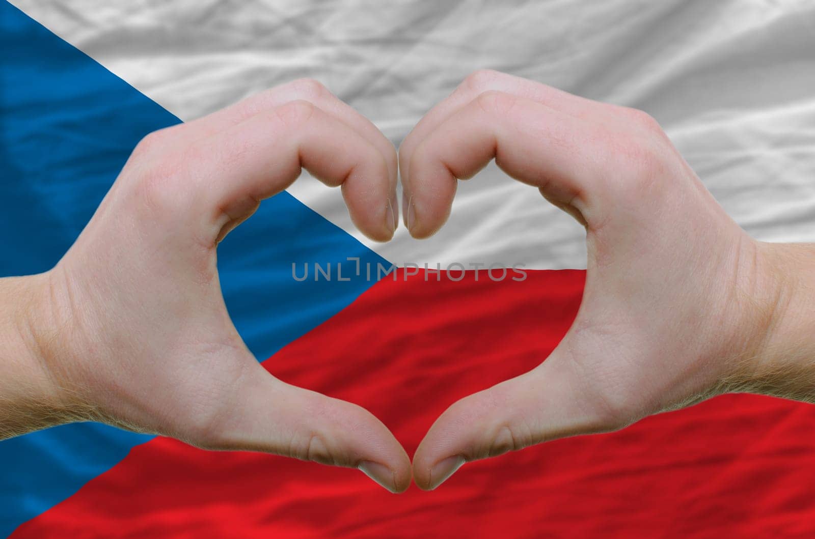 Gesture made by hands showing symbol of heart and love over czech flag