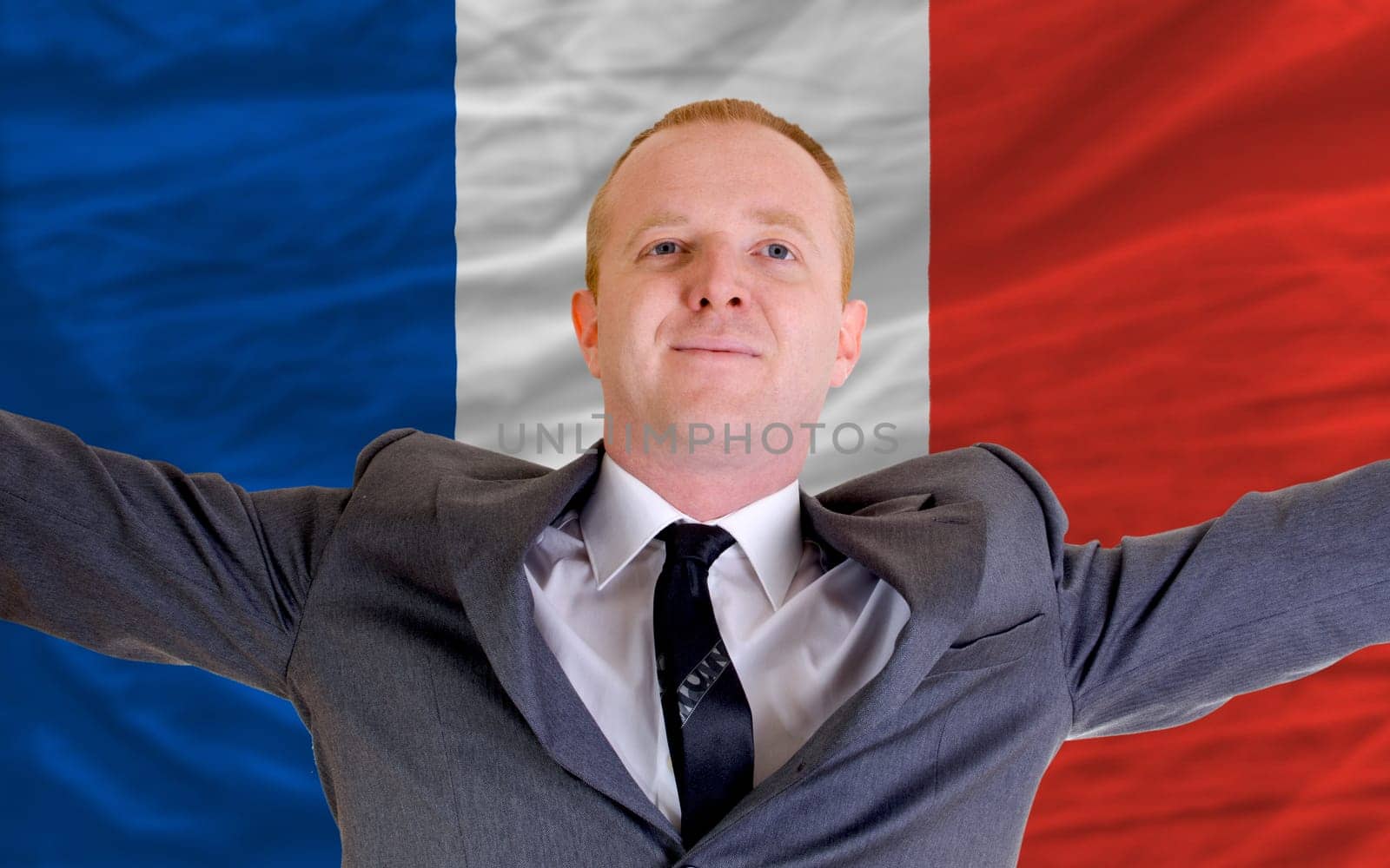joyful investor spreading arms after good business investment in france, in front of flag
