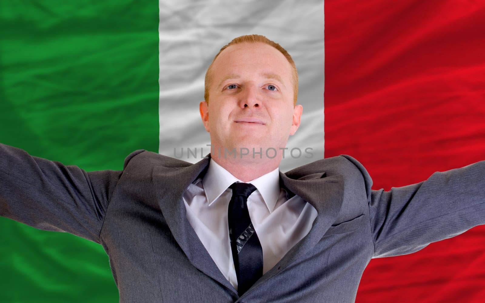 joyful investor spreading arms after good business investment in italy, in front of flag