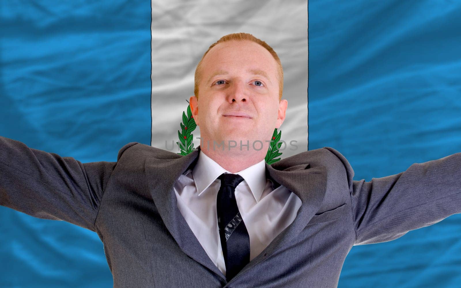 joyful investor spreading arms after good business investment in guatemala, in front of flag