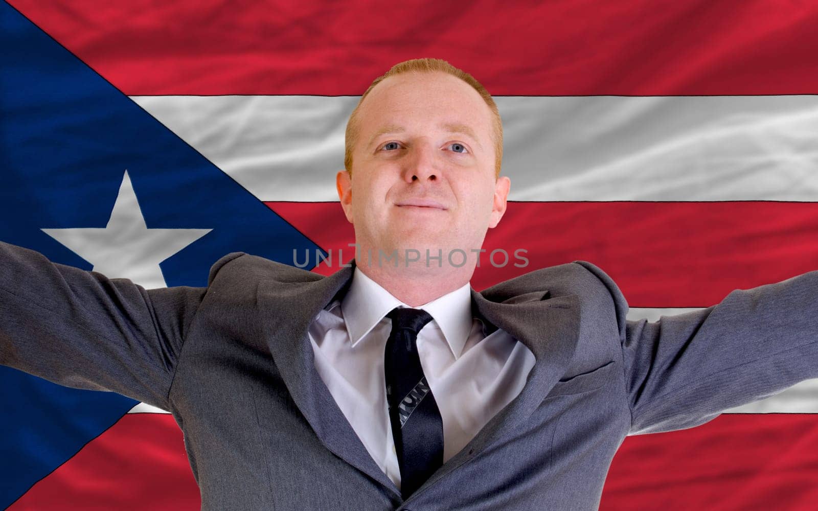 joyful investor spreading arms after good business investment in puertorico, in front of flag