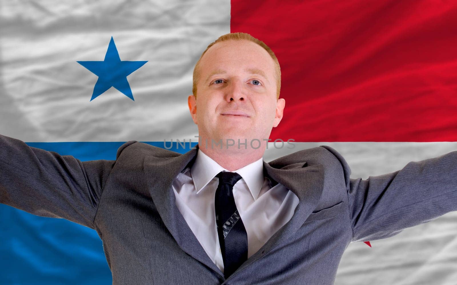 joyful investor spreading arms after good business investment in panama, in front of flag